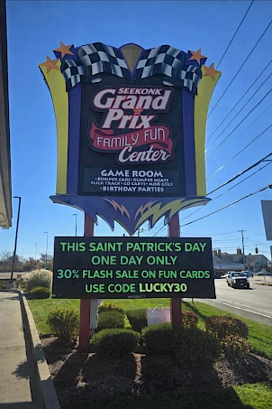 A large colorful sign for Grand Prix Family Fun Center with &ldquo;THIS SAINT PATRICK'S DAY ONE DAY ONLY&rdquo; and a 30% off flash sale on fun cards; use code LUCKY30.
